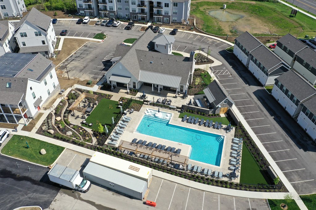 An aerial view of a resort with a swimming pool and a parking lot.