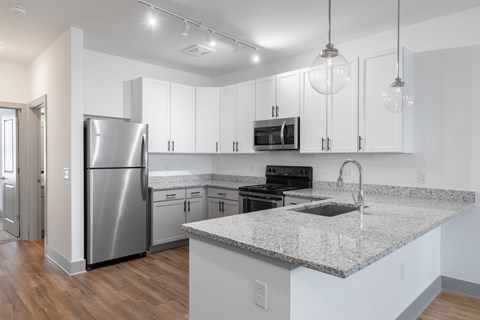 A kitchen with a granite countertop and stainless steel appliances.