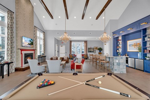 A billiard table is in the middle of a living room.