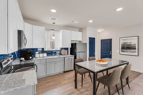 A modern kitchen with a dining table and chairs.