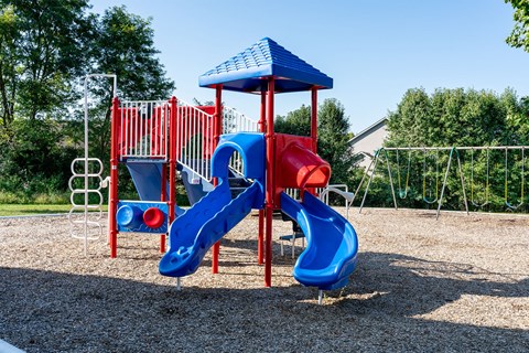 a playground with a blue and red swing set