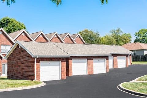 a brick building with three garages in front of it