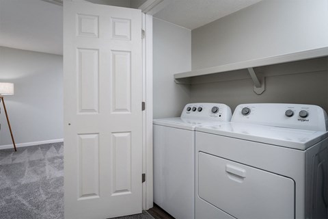 a washer and dryer in a laundry room with a white door