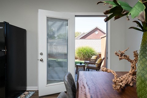 a dining room with a sliding glass door to a backyard