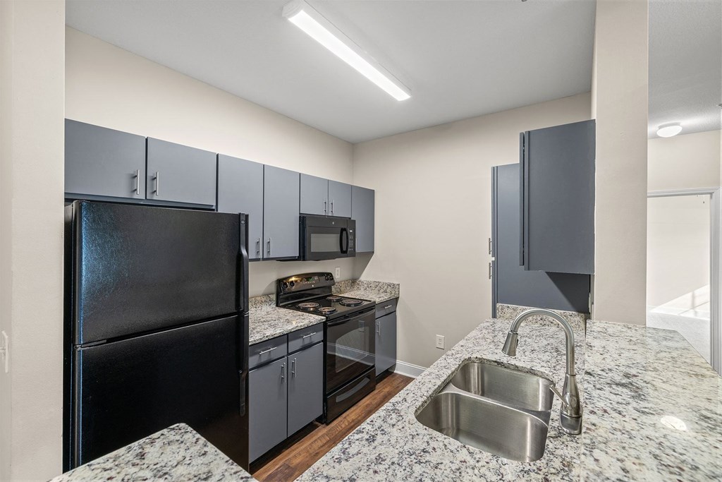 A kitchen with granite countertops and stainless steel appliances.