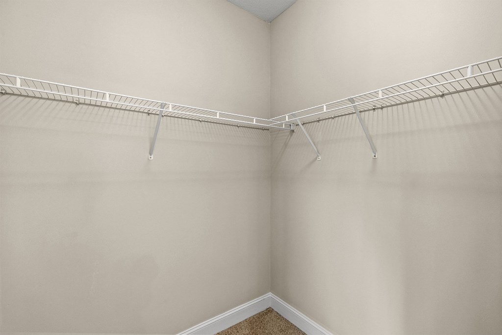 Empty white closet with a white shelf.