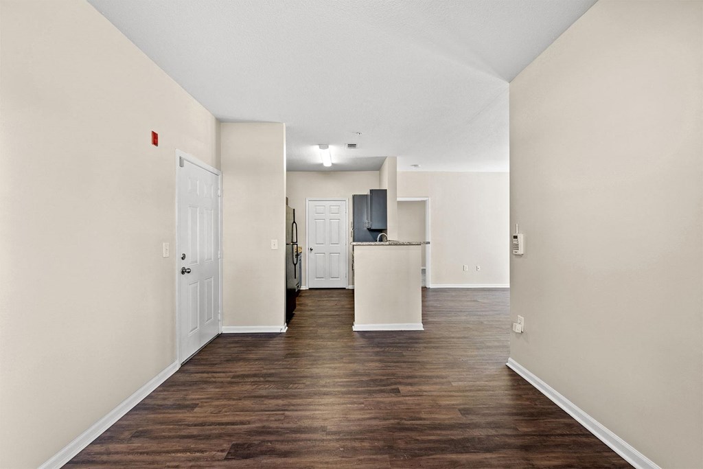 A long hallway with a white door on the left and a white door on the right.