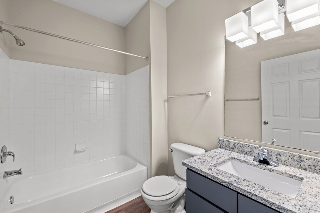 A white bathroom with a toilet, sink, and bathtub.