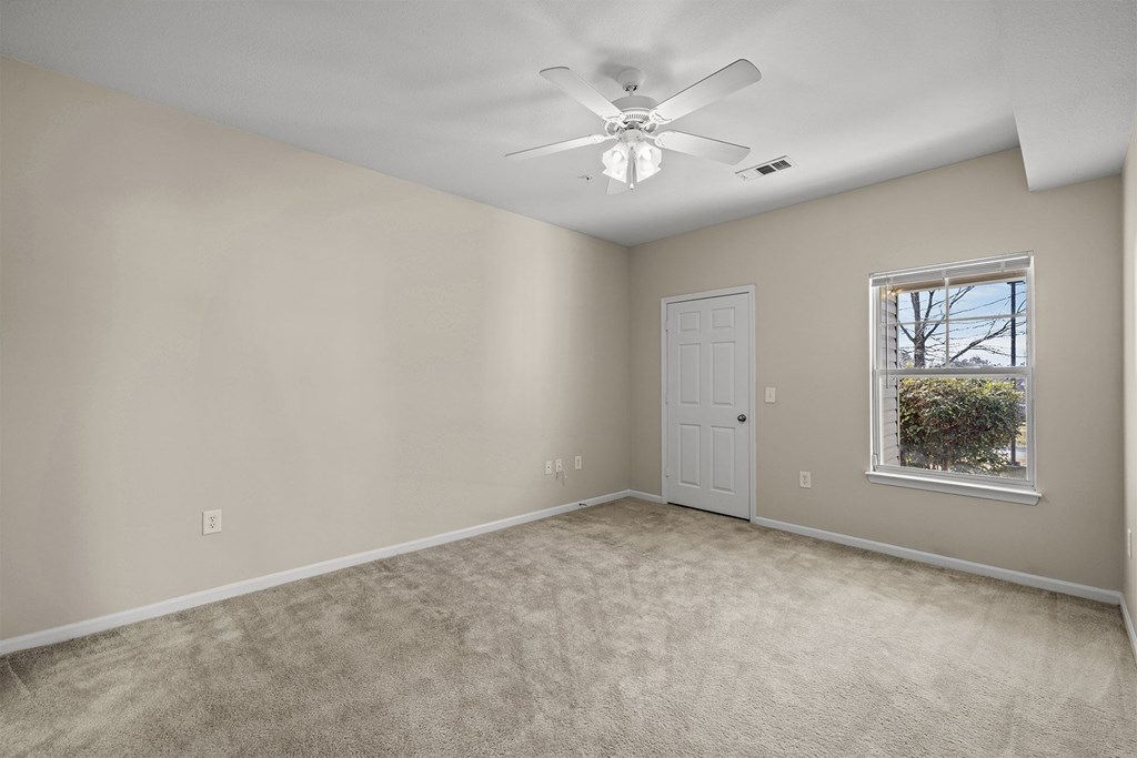 A room with a ceiling fan and a window.