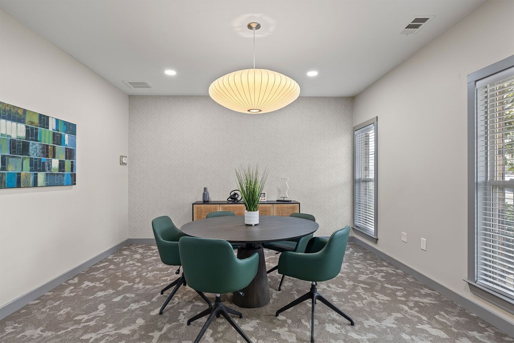 A dining room with a round table and chairs.