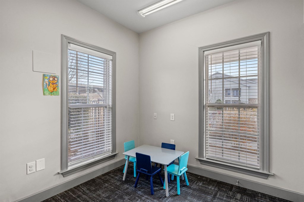A room with a table and chairs by the window.