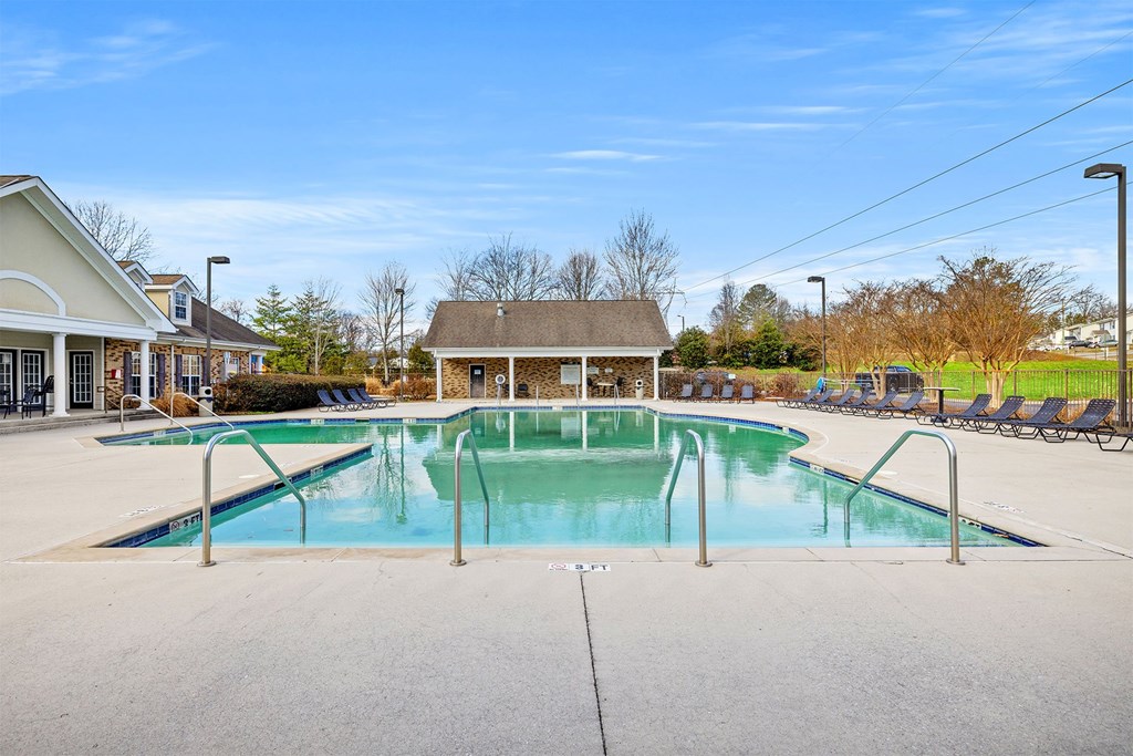 A large swimming pool with a diving board in the middle of a residential area.