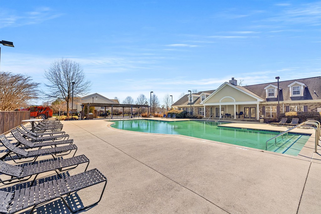A large outdoor swimming pool surrounded by lounge chairs.