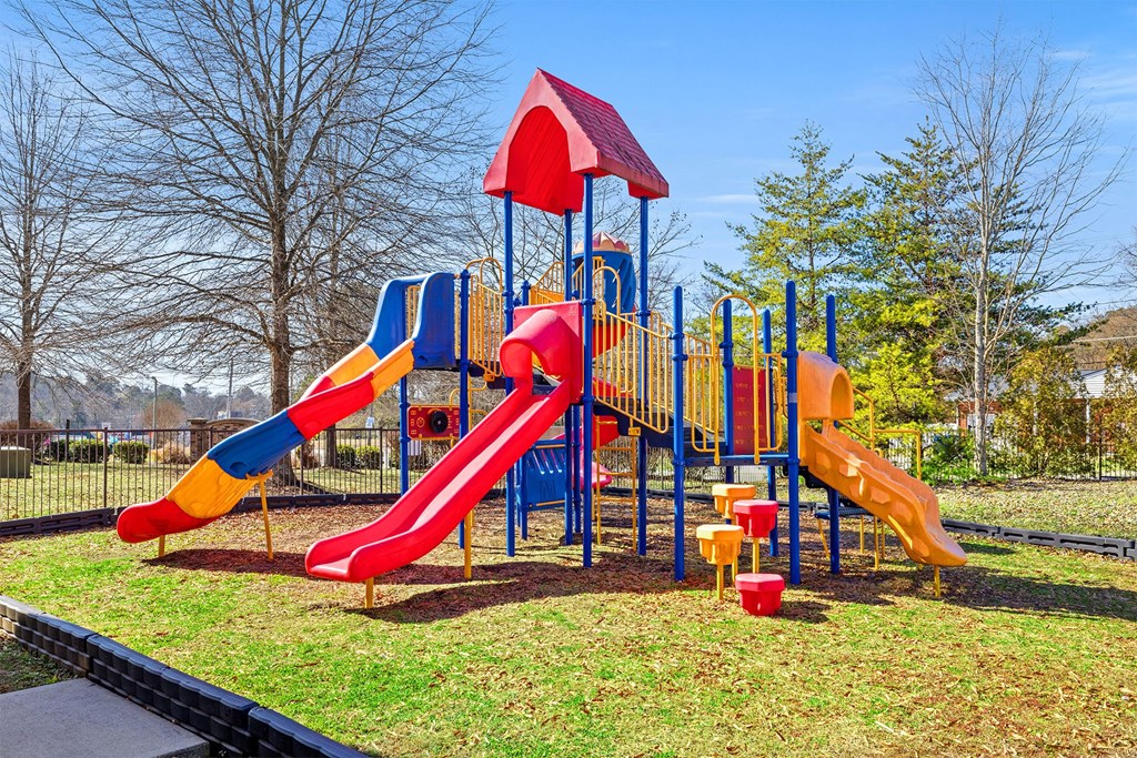 A playground with a red, yellow and blue slide.