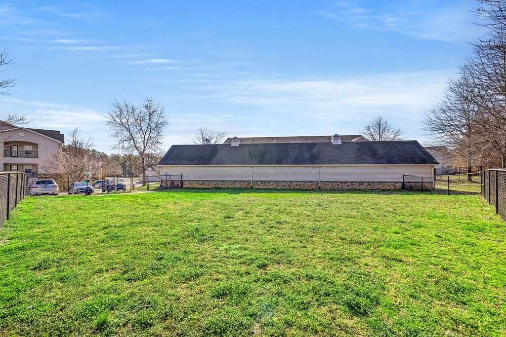 A large grassy field with a building in the background.