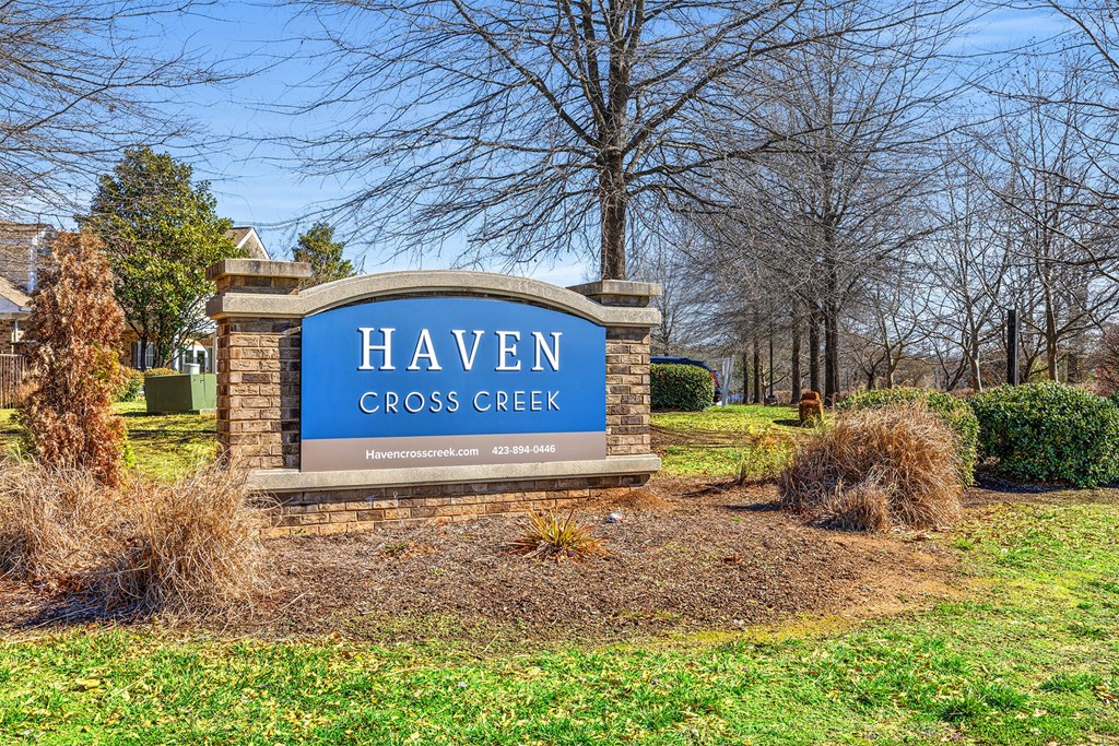 A sign that says Haven Cross Creek in front of a tree.