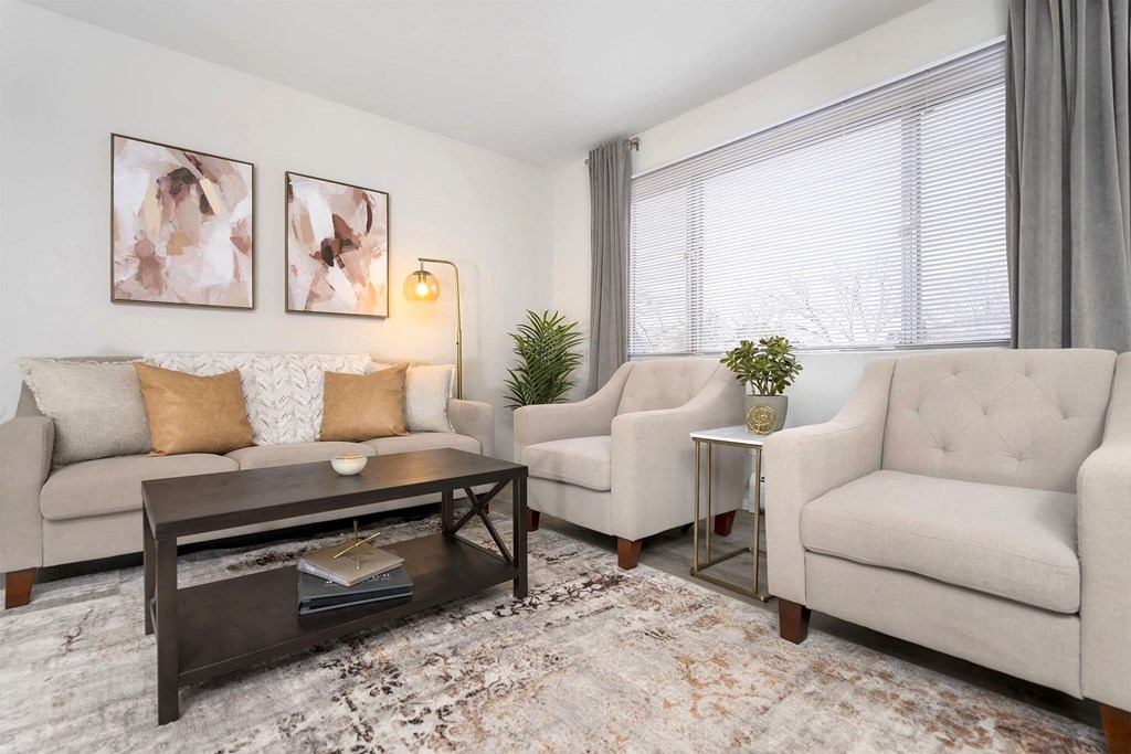 living room with neutral color sofa and chairs and a dark wood center coffee table