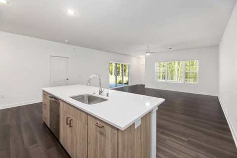 A kitchen with a white countertop and wooden cabinets.