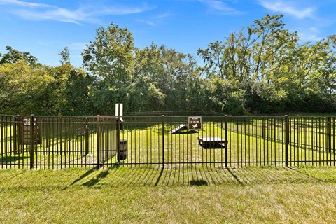 a yard with a fence and benches in the grass