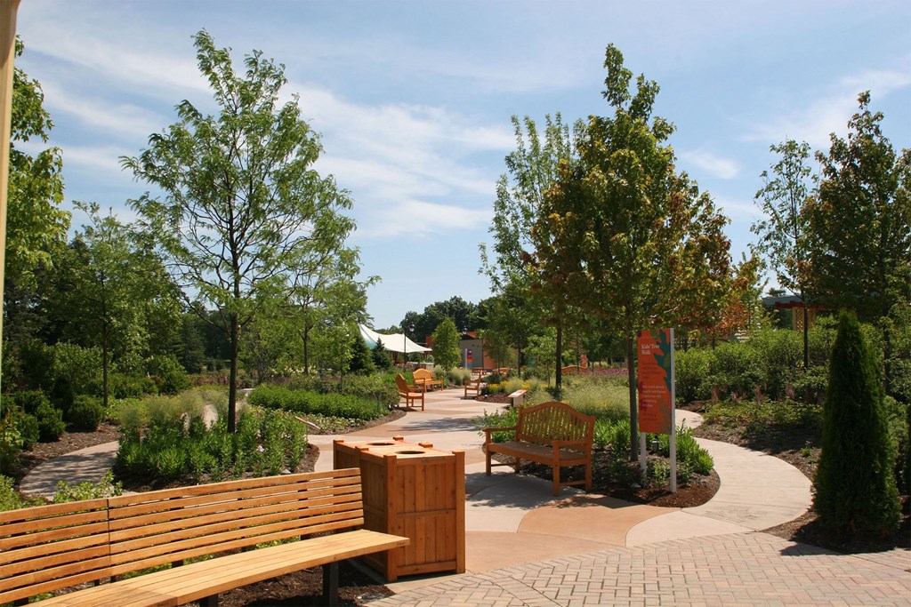a park with benches and trees and a sign