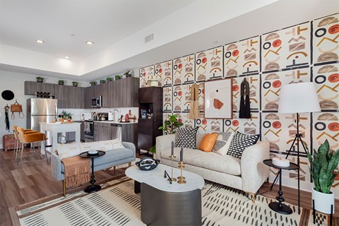 A modern living room with a white couch, a coffee table, and a patterned wallpaper.