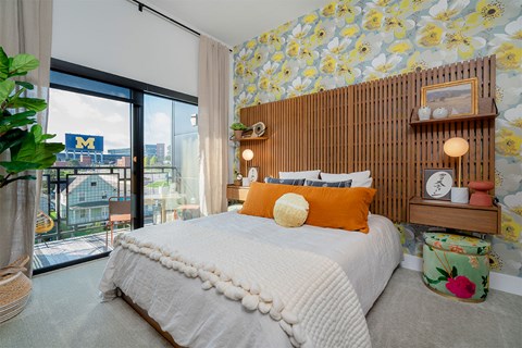 A bedroom with a large bed and a wallpapered wall.