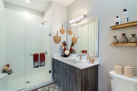 A bathroom with a white tub, sink, and shower.