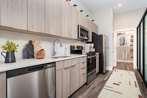 A modern kitchen with wooden cabinets and stainless steel appliances.