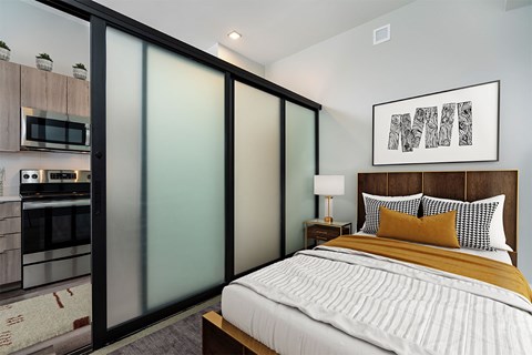 A bedroom with a bed, nightstand, and a framed picture on the wall.