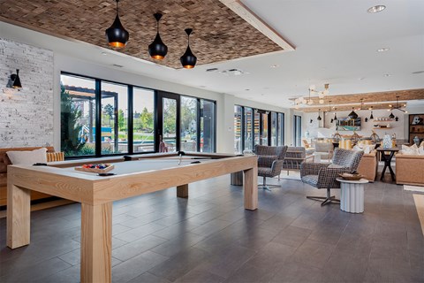 A modern dining room with a long wooden table and chairs.