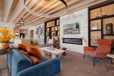 A living room with a blue couch and a fireplace.