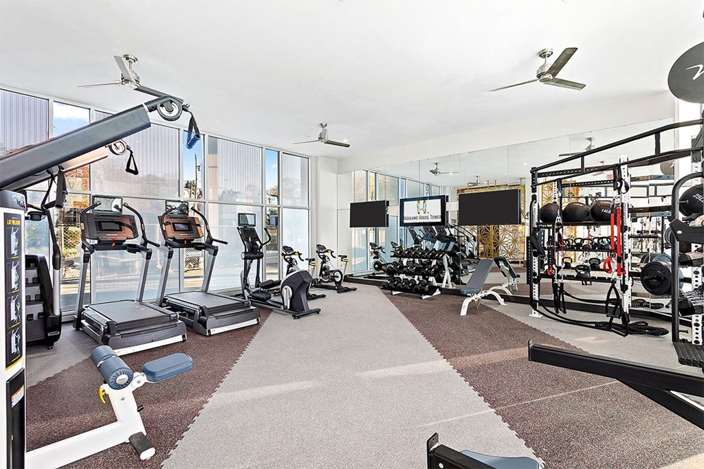 the home has a gym with glass walls and weights and cardio equipment