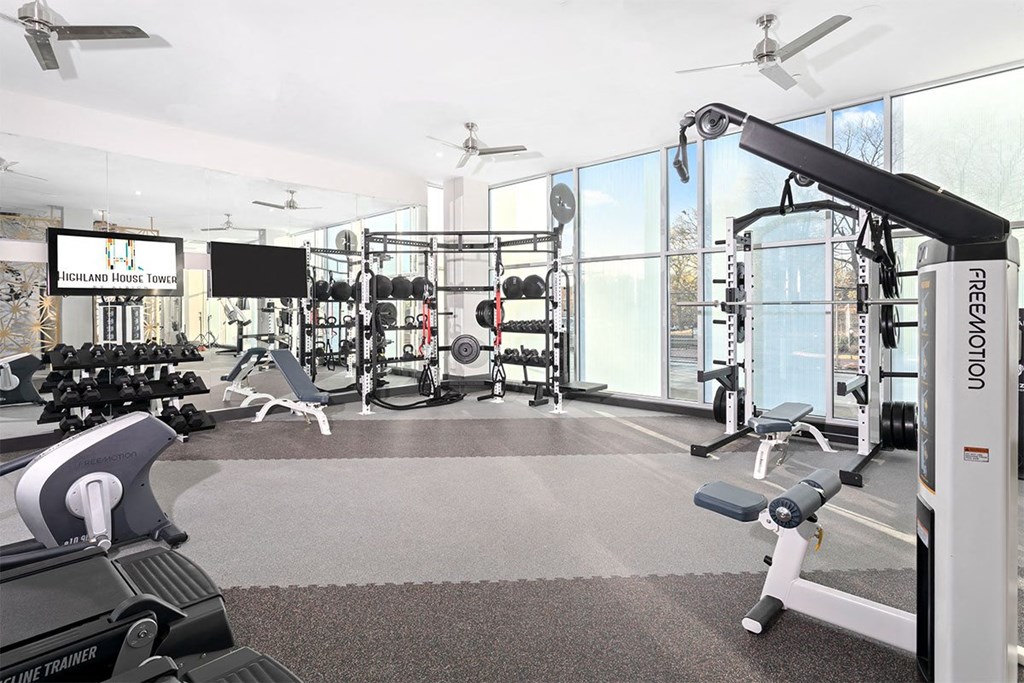 a gym with weights and other gym equipment and a large window