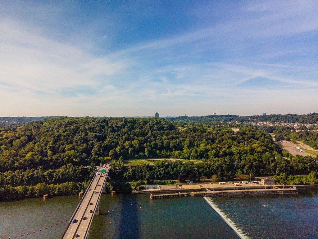 an aerial view of a bridge over a river with a city in the background