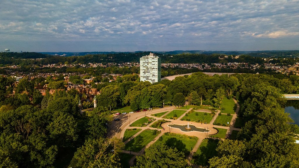 an aerial view of a park and a tall building