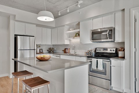 A modern kitchen with white cabinets and stainless steel appliances.