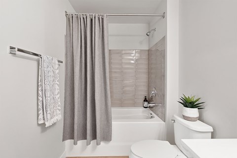 A bathroom with a white tub, toilet, and sink.