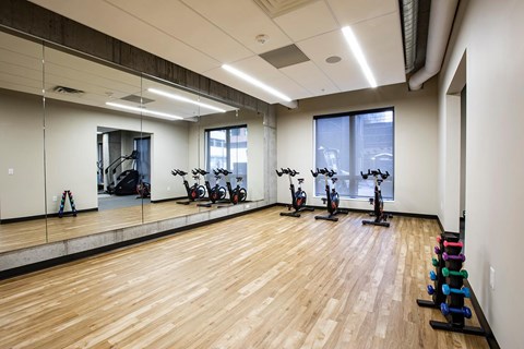 A gym with wooden floors and exercise equipment.