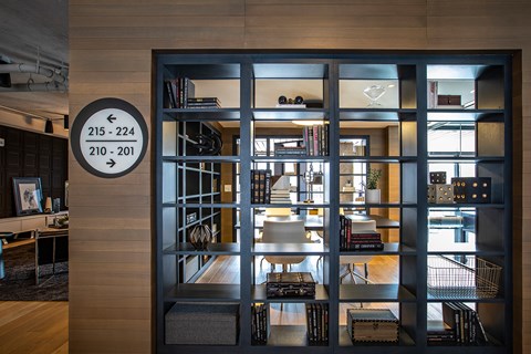 A black and white sign on a door with a room in the background.