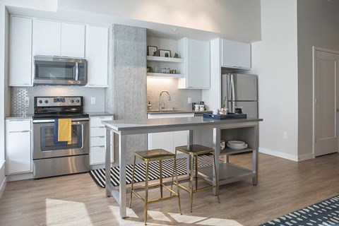 A modern kitchen with a stainless steel oven and microwave.