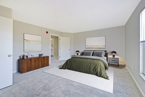 A bedroom with a bed, nightstand, and a painting on the wall.