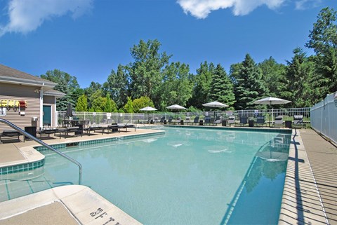 the resort style swimming pool is next to the poolside tables and umbrellas