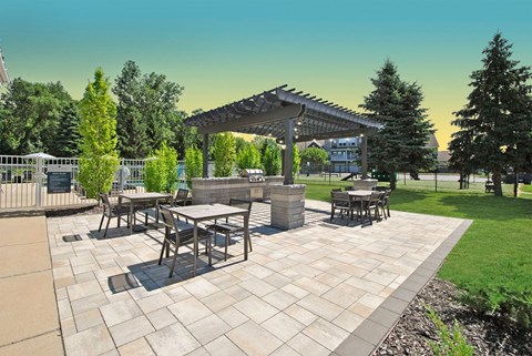 a patio with tables and chairs and a pergola
