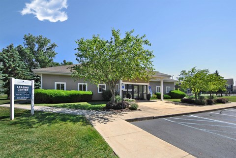 a building with a parking lot and a sign in front of it