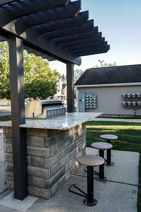 A concrete bar with a black pole and a black umbrella.