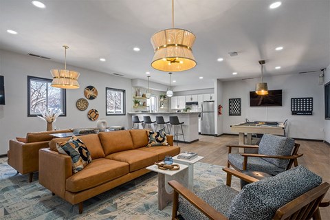 a living room with couches and chairs and a kitchen