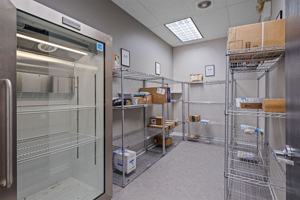 a room with a refrigerator and shelves with boxes in it