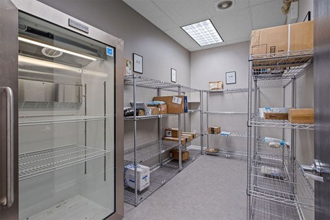 a room with a refrigerator and shelves with boxes in it