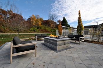 a patio with chairs and a fire pit