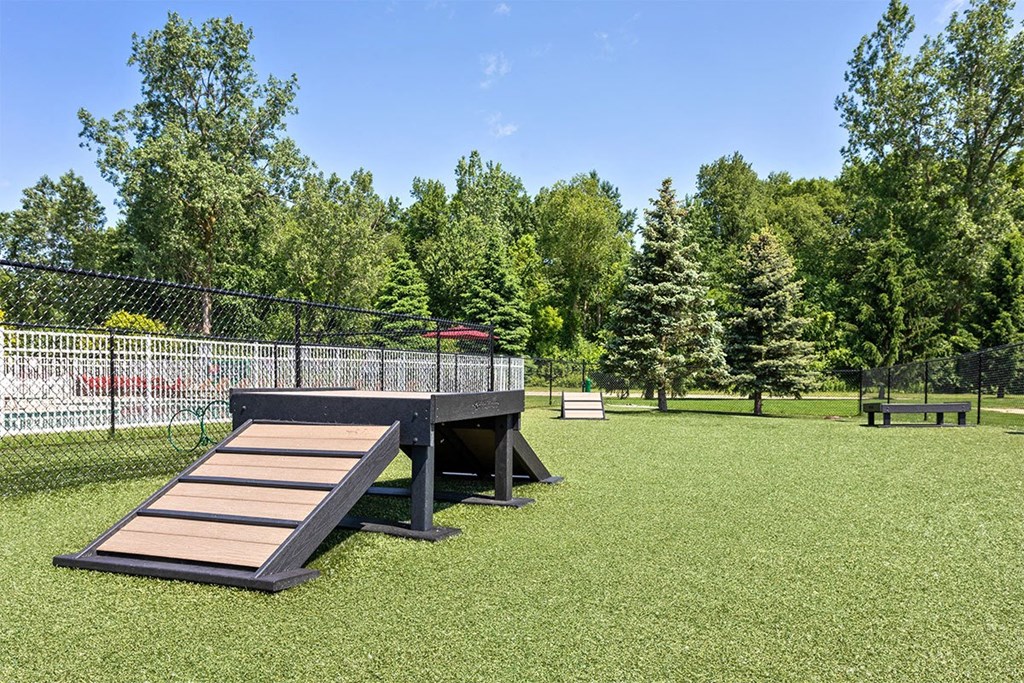 a picnic table in a park next to a fence